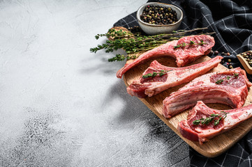 Raw fresh lamb ribs with pepper and thyme. Organic meat. White background. Top view. Copy space