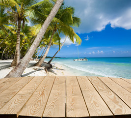 Empty wooden tabletop for Your product advertisement. Tropical beach in the background. Summer holiday concept