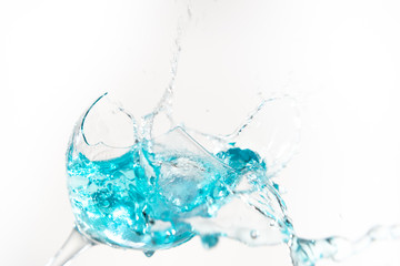 Naklejka na ściany i meble Water splashing into a broken glass