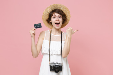 Excited young tourist girl in dress hat with photo camera isolated on pink background. Female...