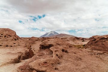 Rocky landscape mountain background. Dry, Barren desert, snowcapped mountains wilderness. Mountain range view. Salt Flats of Uyuni, Bolivia. Copy space, Rocks, blue sky, nature, hiking, sand dust