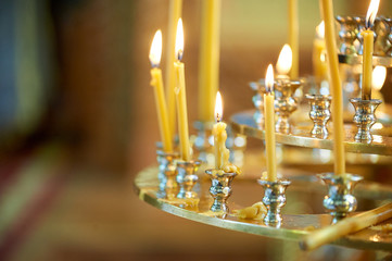 Three-tier candlestick with candles in the Orthodox Church