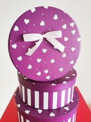 Purple gift box with circle striped box cover with purple ribbon and a bow isolated