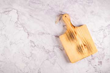 Wooden cutting board on a gray marble background