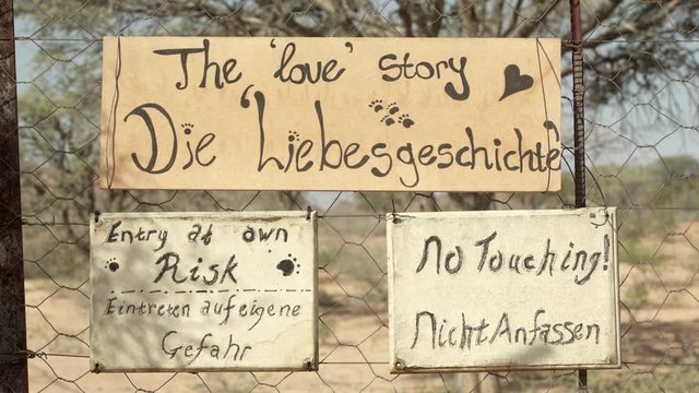 Close-up of handwritten sign boards on chainlink fence at zoo - Etosha National Park, Namibia