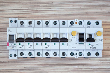 Electrical circuit breakers, RCD, residual current devices and differential circuit breakers are arranged in a row. Devices for distribution of electricity, protection of human life from electricity.