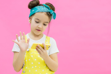 Little girl looking in her phone and choosing the best shot.