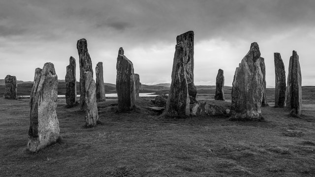 Ancient neolithic Callanish Stones are standing stones placed in a cruciform pattern with a central stone circle. Neolithic era, ritual focused in monochrome