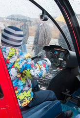 
A child at the helm of a helicopter in the rain.