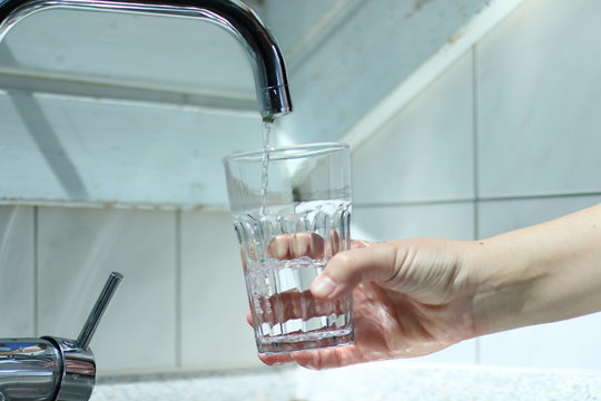 Wasser in das Glas gie&szlig;en