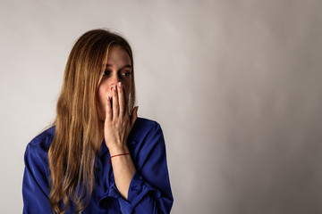 Sleepy young woman in blue. Girl yawning.