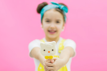 Little girl holding sweet lollipop candy in front of camera.