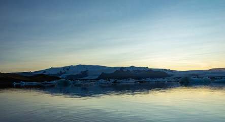 Fjallsarlon, Jokulsarlon glacier lagoon in Iceland during blue hour and sunset. Wanderlust and holiday concept.