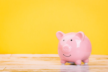 pink piggy bank on a yellow background, space for text. Finance, saving money, crisis. Business or Retirement Savings