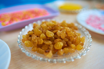 Glass plate with fresh yellow raisins. Selective view