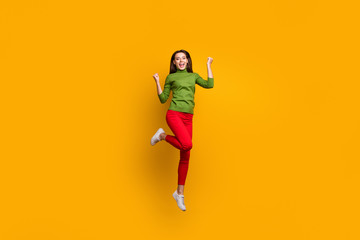 Fototapeta na wymiar Full length photo of positive cheerful girl celebrate lottery win raise fists scream yeah feel crazy emotions ear good looking clothing isolated over vivid color background