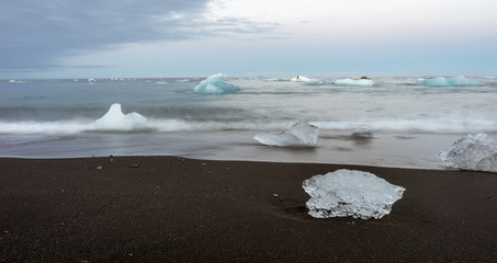 Icy black beach in Iceland called diamond beach during blue hour with pink skies, long exposure photography. Travelling and holiday concept.
