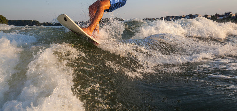 Man surfing on the Surfboard pulled by a motor boat over the boat wave Wakeboarder surfing fun leisure activity family outing water sports sporting health challenge