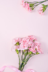 Naklejka na ściany i meble Mother's Day, Valentine's Day background design concept, beautiful pink carnation flower bouquet on pastel pink table, top view, flat lay, copy space.