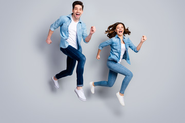 Fototapeta na wymiar Full size photo of cheerful spouses man woman jump run enjoy spring weekend rest relax wear good look clothes footwear isolated over gray color background