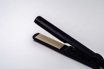 Hair iron to straighten hair on a white background