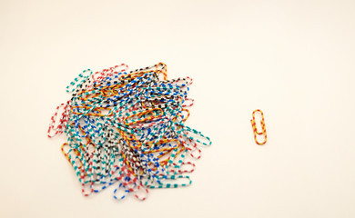 One and many multicolored paper clips. Concept