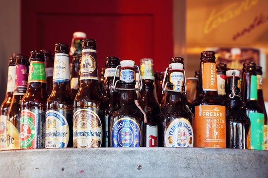 Variety of beer bottles with different brands displayed in a pub counter