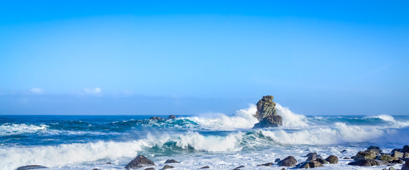 Panorama of high waves breaking on rocks