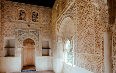 Room with Islamic calligraphy on walls, interiors of the 14th-century fortress, in medieval Arabic style. Spain.