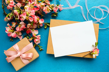 postcard mockup. flowering branch with pink flowers, gift box and space for text. congratulation. invitation