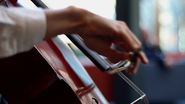 A man playing the cello. Close up of a man playing fast notes with a bow on a cello.