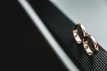 Close up of wedding rings on a black leather belt