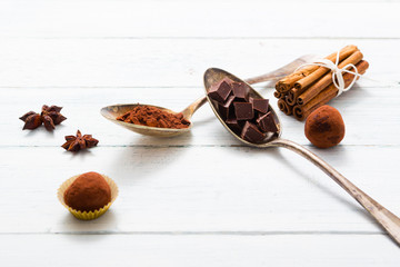 chocolate truffles, cocoa powder, broken dark chocolate on white wooden