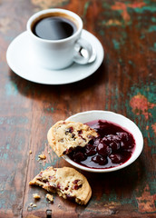 Cranberry cookies with jam on rustic wooden background. Close up.