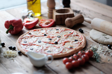 pizza with sausage and ingredient on the wooden table in rustik style