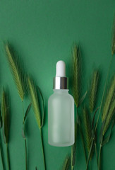 Glass bottle essential collagen anti-aging serum with vitamin A and vitamin E on blue paper...