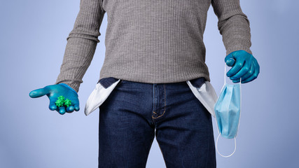 Male half body view. Protected man with gloves and surgical mask, shows the pockets of his empty pants. Concept of crisis and economic recession caused by coronavirus and covid-19.