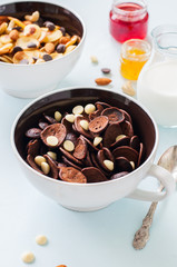 Chocolate tiny pancake cereals with white chocolate drops in a bowls.