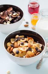 Vanilla tiny pancake cereals with nuts and chocolate drops in a bowls.