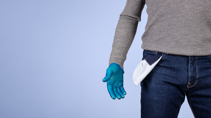 Male half body view. A hand protected by surgical gloves shows the pocket of his empty pants. Concept of crisis and economic recession caused by coronavirus and covid-19.