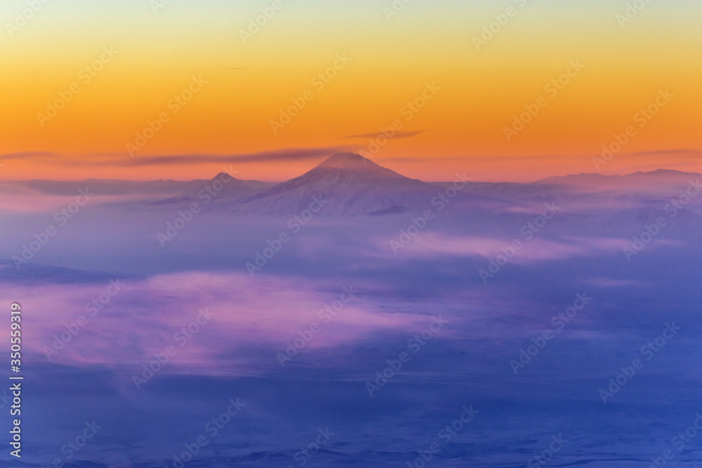 Poster Sunrise over Caucasus Mountains seen from passenger plane window