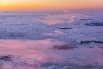 Sunrise over Caucasus Mountains seen from passenger plane window
