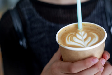 Close-up of female preteen  holding the cup with coffee