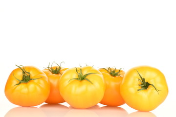 Fresh juicy organic yellow tomatoes, close-up, on a white background.
