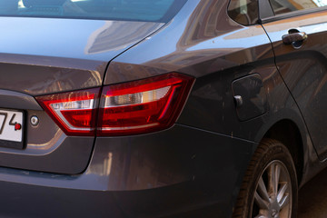 Obraz na płótnie Canvas The taillight of a car. Dark car, headlight close-up. The photo