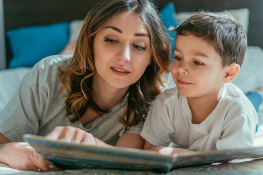 Selective Focus Of Attractive Mother And Happy Toddler Boy Looking At Book