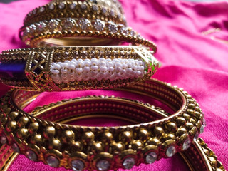 Close up of Indian style designer bangles with pink background