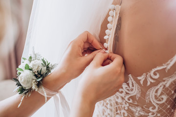 The bride wears a wedding dress, tries on earrings. The bride's morning training camp. women's accessories on wedding day.