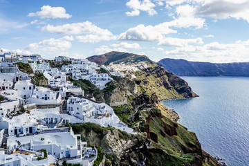 Fototapeta na wymiar White houses near tranquil sea against sky with clouds in Greece