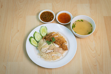 Steam Chicken and Fried chicken with Rice  (Hainan Chicken) on wooden table
